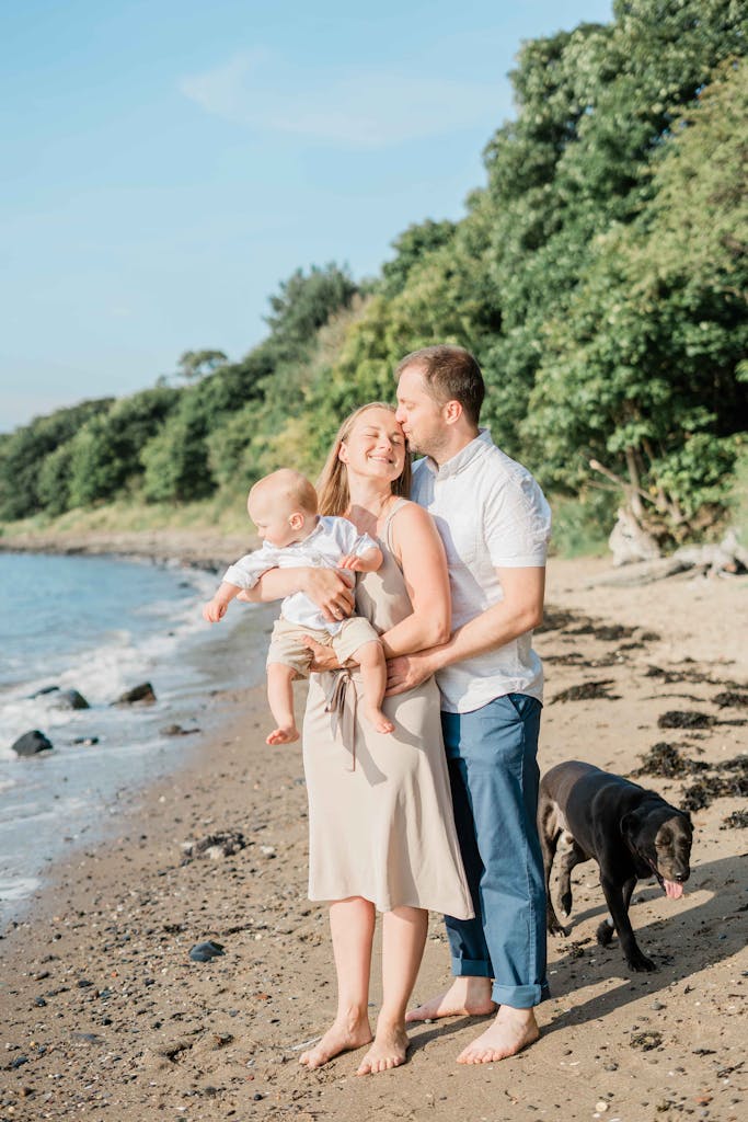 A joyful family with their dog enjoying a sunny day at the beach.