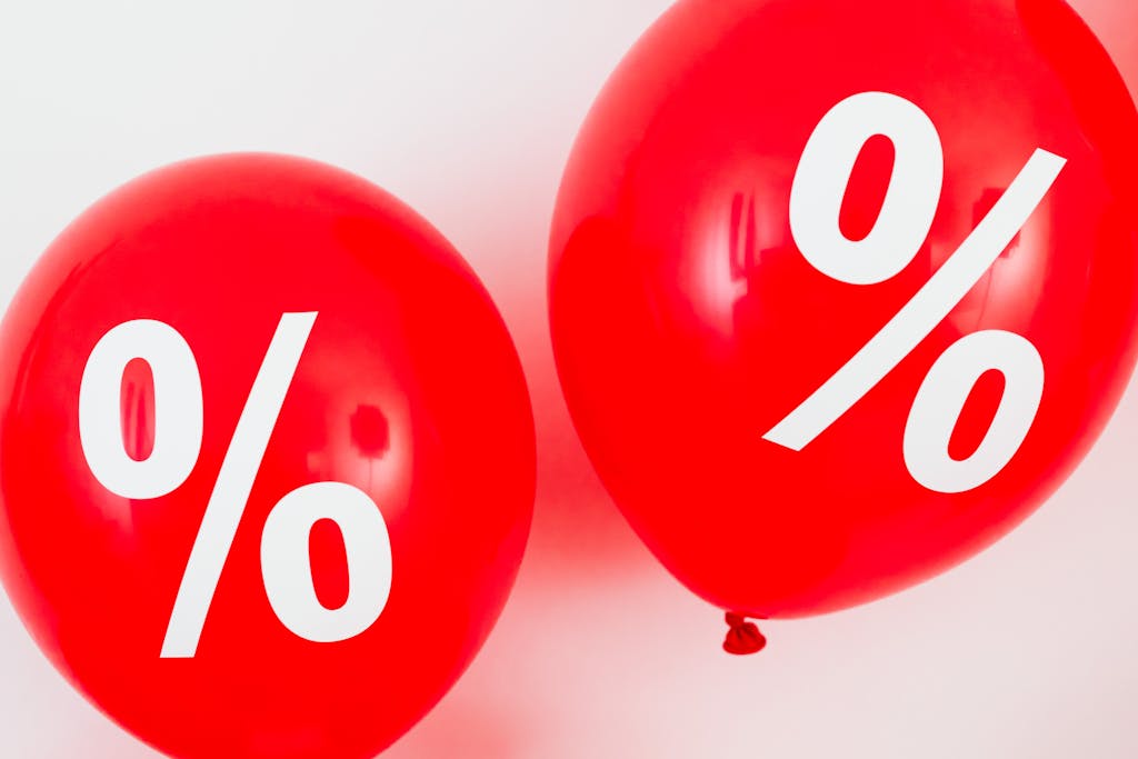 Red balloons featuring percentage symbols, ideal for sales and promotions.