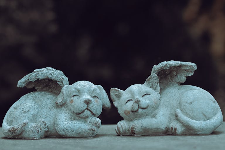 Stone cat and dog with wings add whimsical charm to any garden decor.